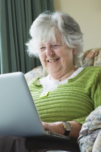 older woman holding a laptop